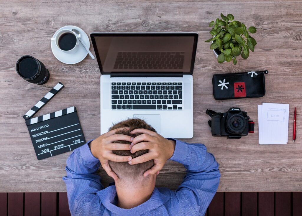 blogger with hands on head at desk