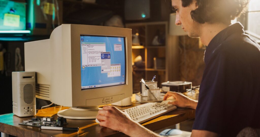 young man using old computer with CRT monitor